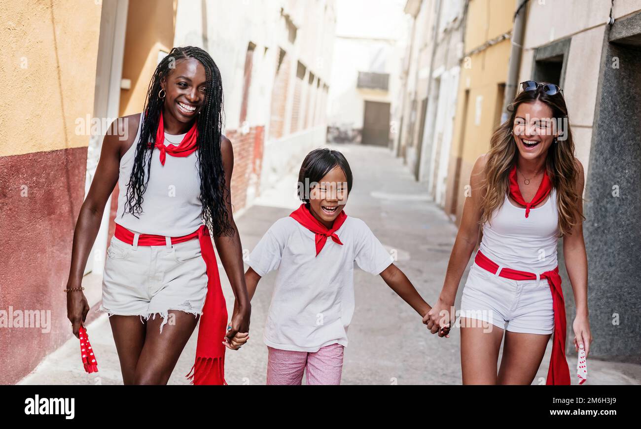 two girls and a boy of different ethnicity, enjoy together the popular festivities of a town in spain. multiracial group. concept of fun, tolerance Stock Photo