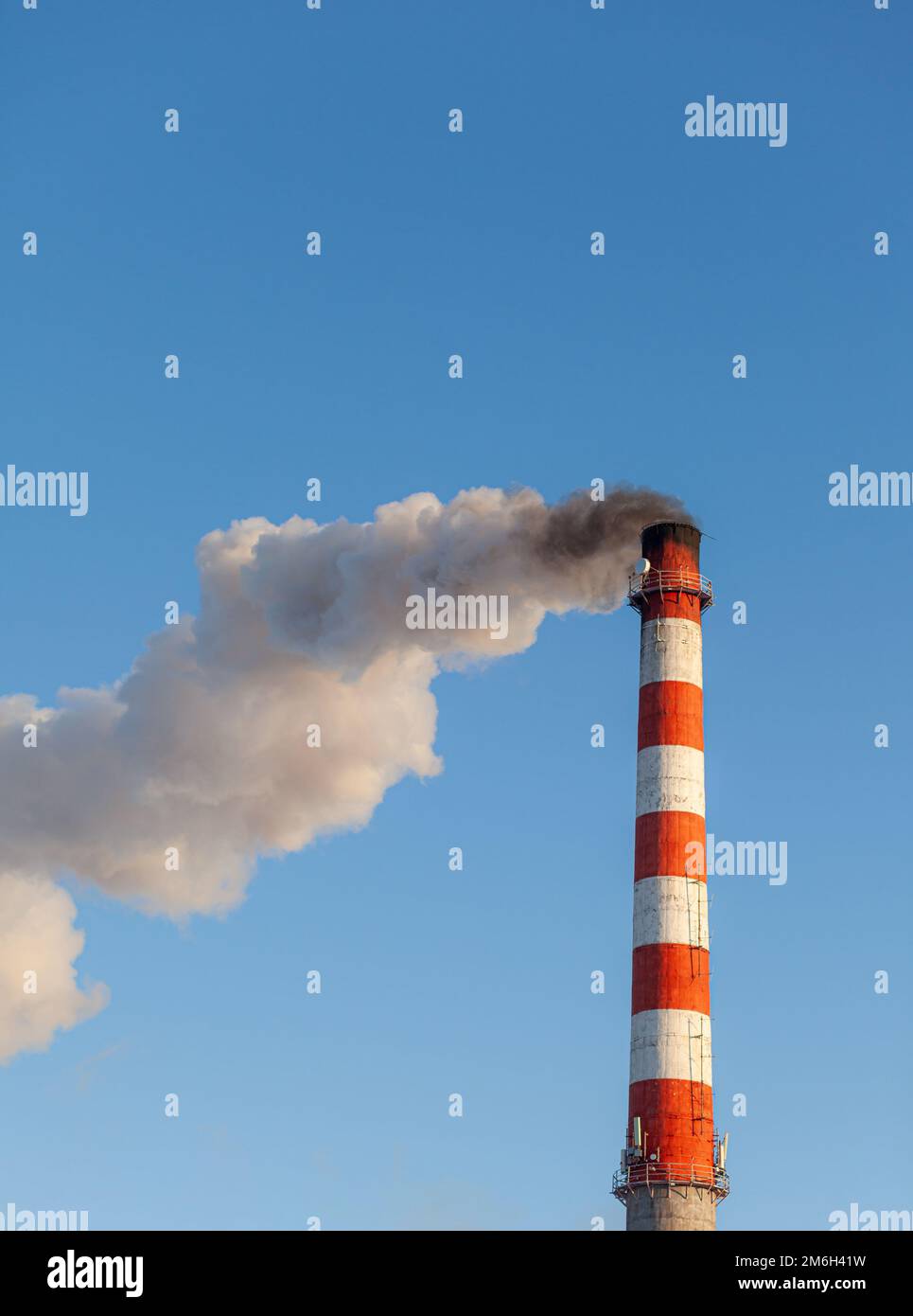 White thick smoke from the boiler room chimney. Industrial zone. Stock Photo