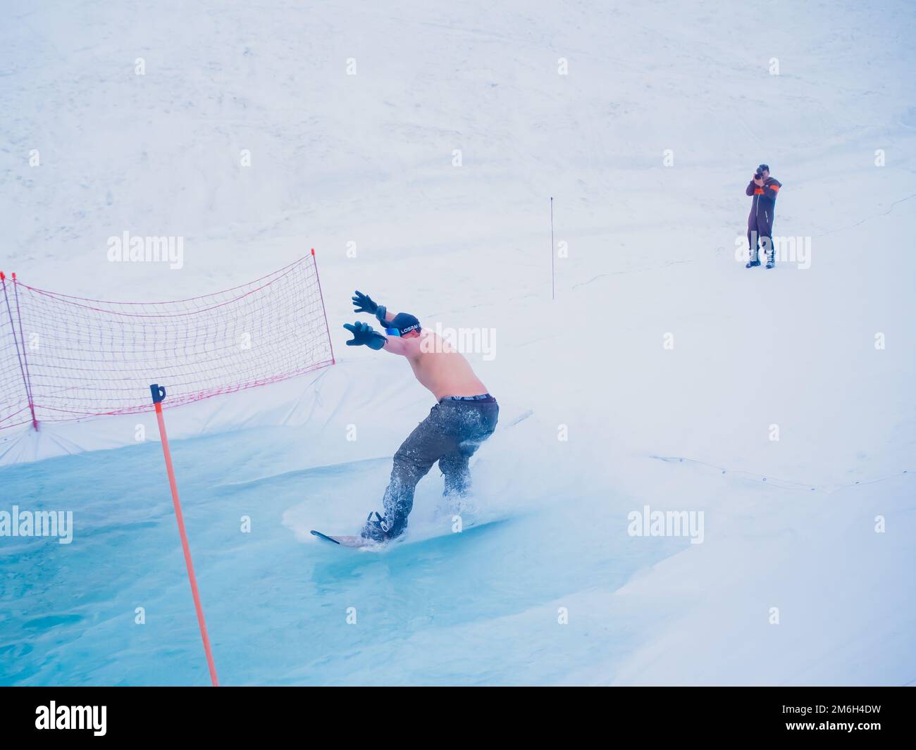 Russia, Sochi 11.05.2019. A guy without outerwear rides a snowboard on the water. You need not to fall and drive to the end. Kra Stock Photo