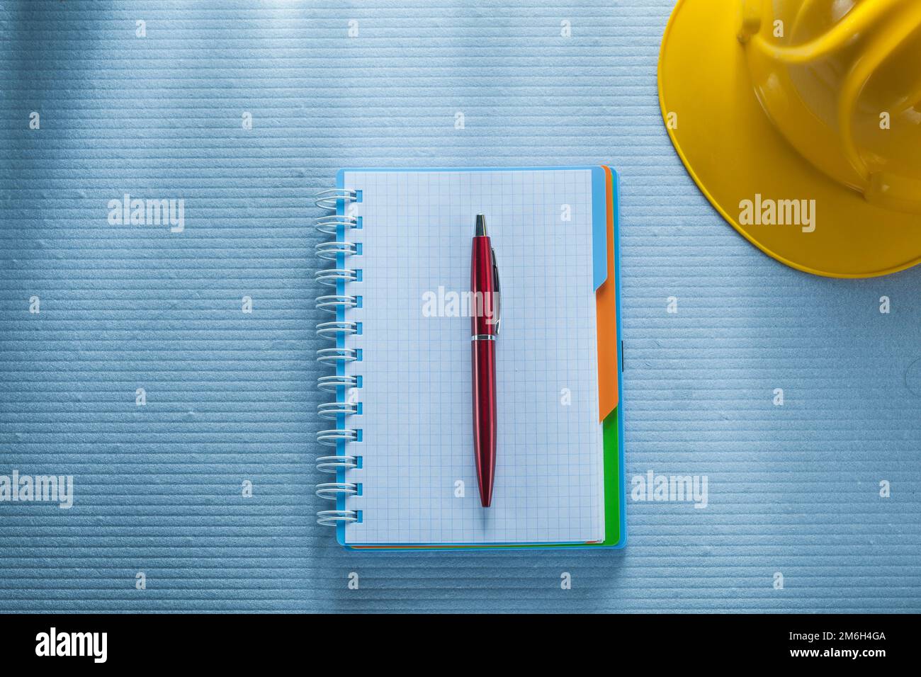 Checked notepad pen building helmet. Stock Photo