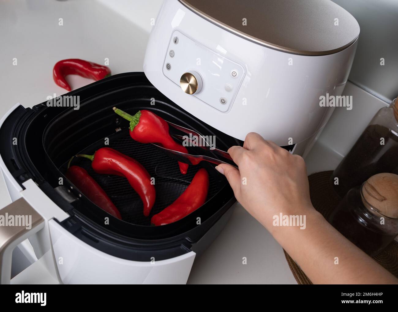 Cooked paprika air fryer for healthier lean food. Woman cooking