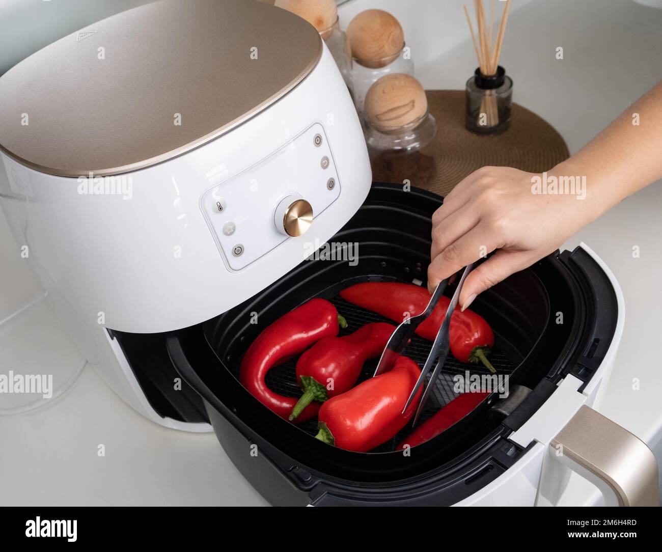 Cooked paprika air fryer for healthier lean food. Woman cooking