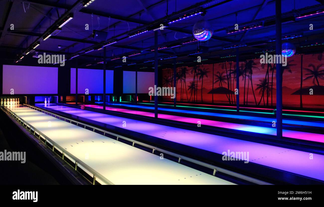 Bowling alley with neon lights in blue and red and white lanes Stock