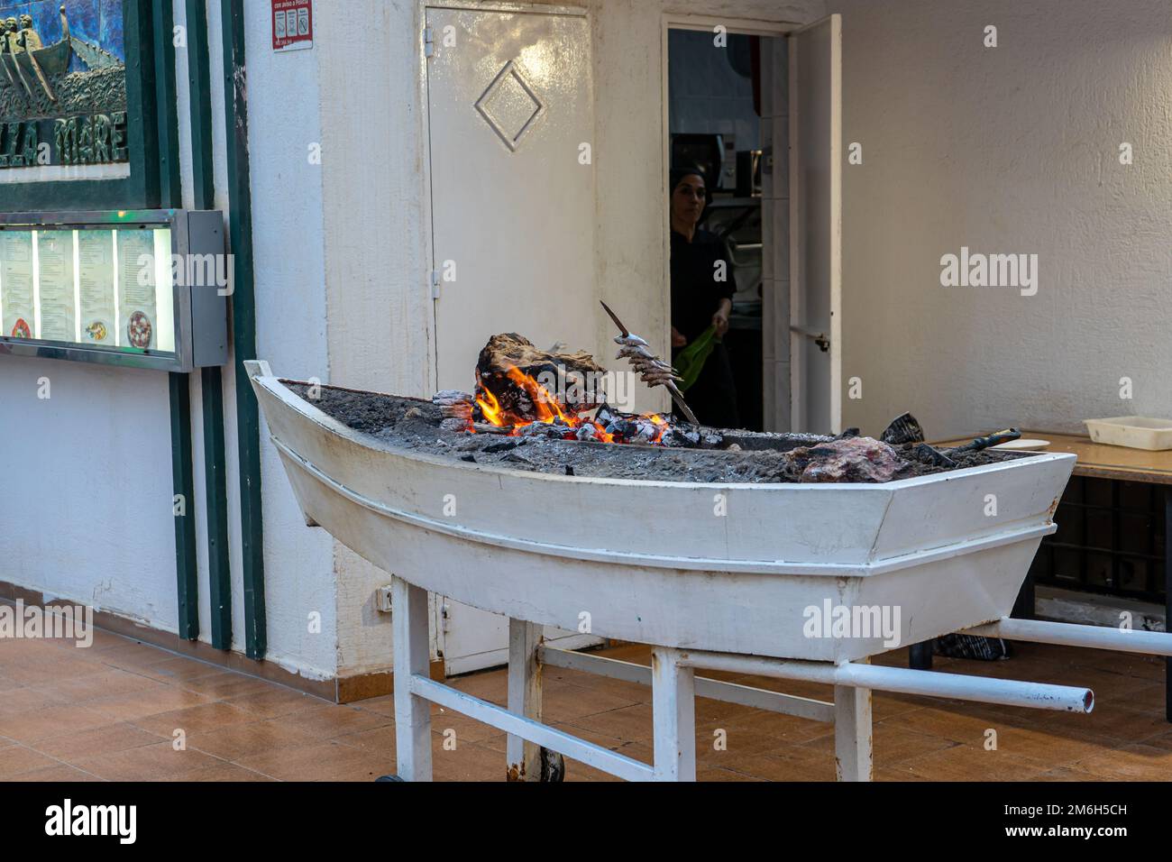 Cooking sardines fish on BBQ using traditional boat Stock Photo Alamy