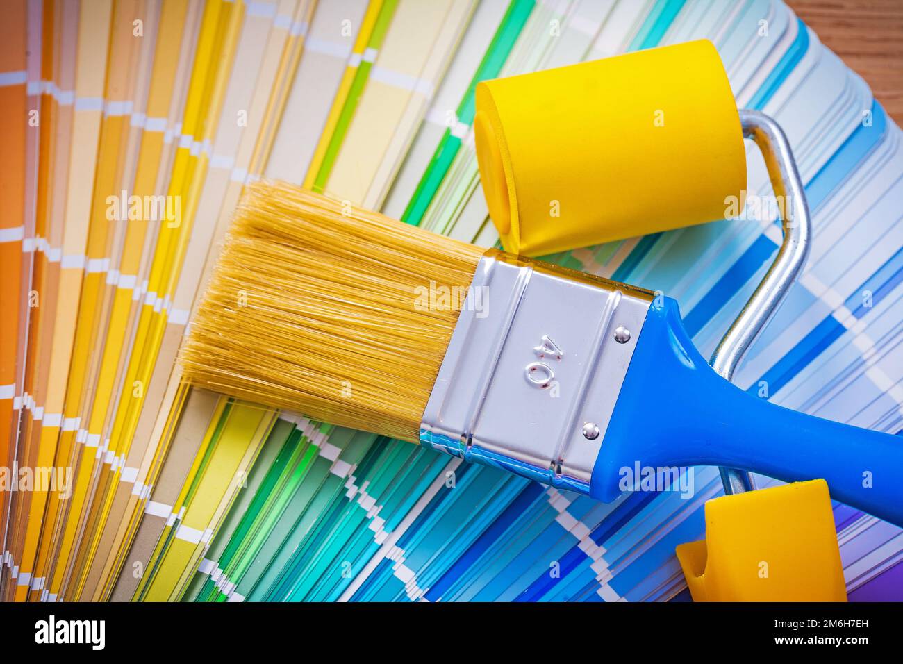 paintbrush and paint roller on color palette Stock Photo Alamy