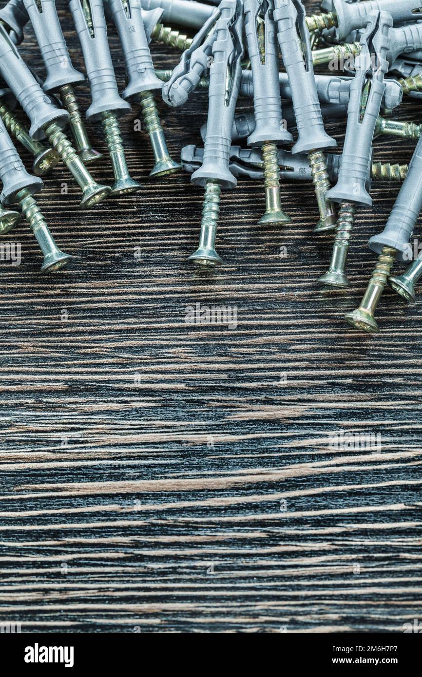 Plastic dowel nails on wooden board. Stock Photo