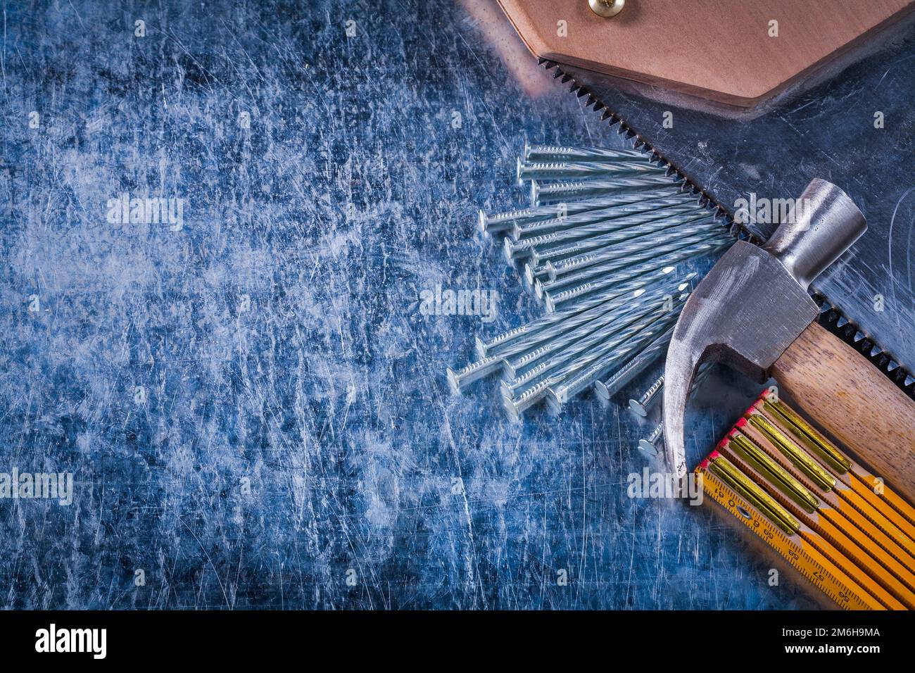 Set of hand saw nails wooden meter and claw hammer on scratched