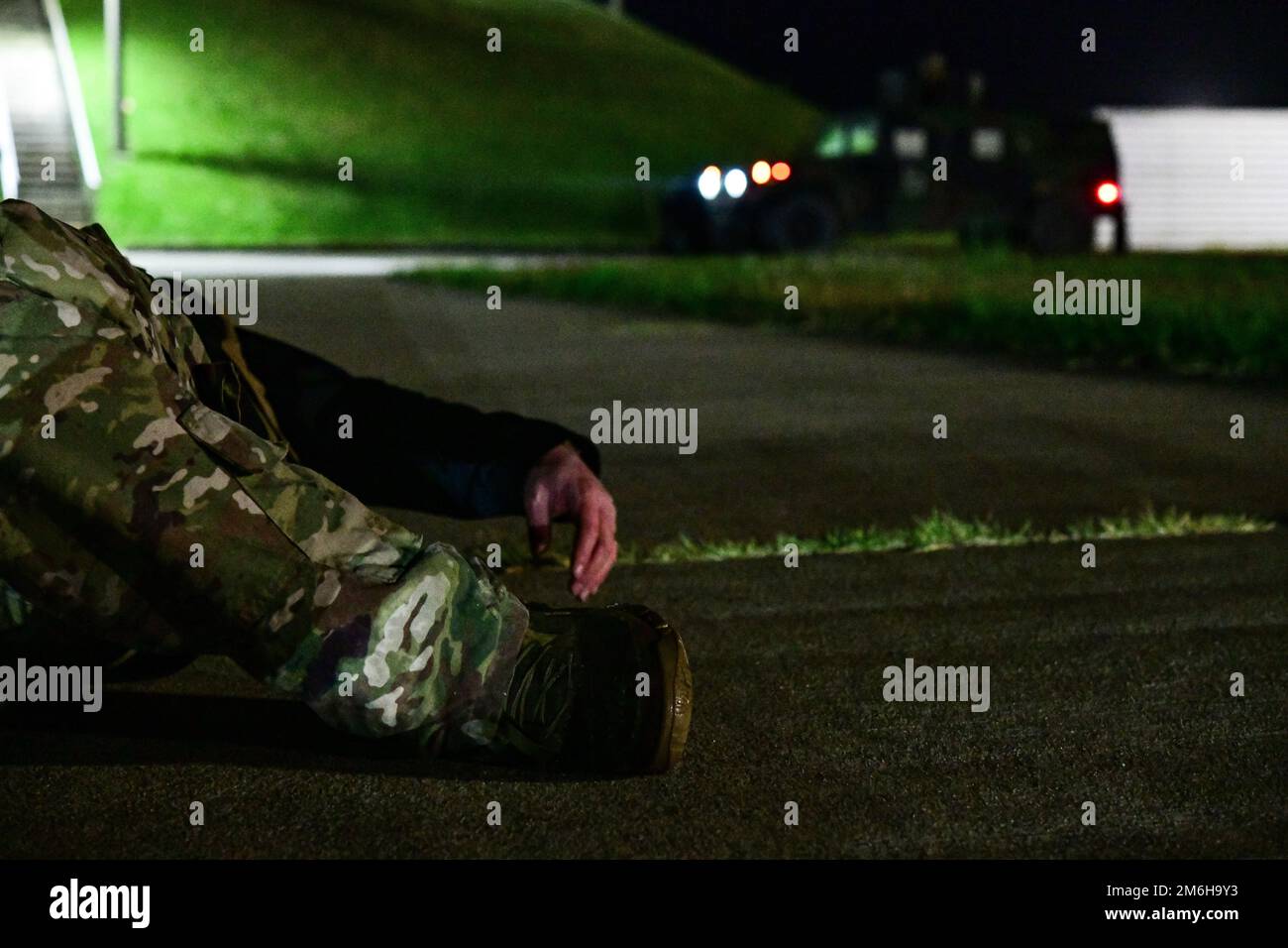 A simulated base intruder lies on the ground during a routine training event (RTE) at Kunsan Air Base, Republic of Korea, April 28, 2022. Simulated ground attacks allow 8 SFS to sharpen their skills by defending the installation and neutralizing adversarial personnel. Stock Photo