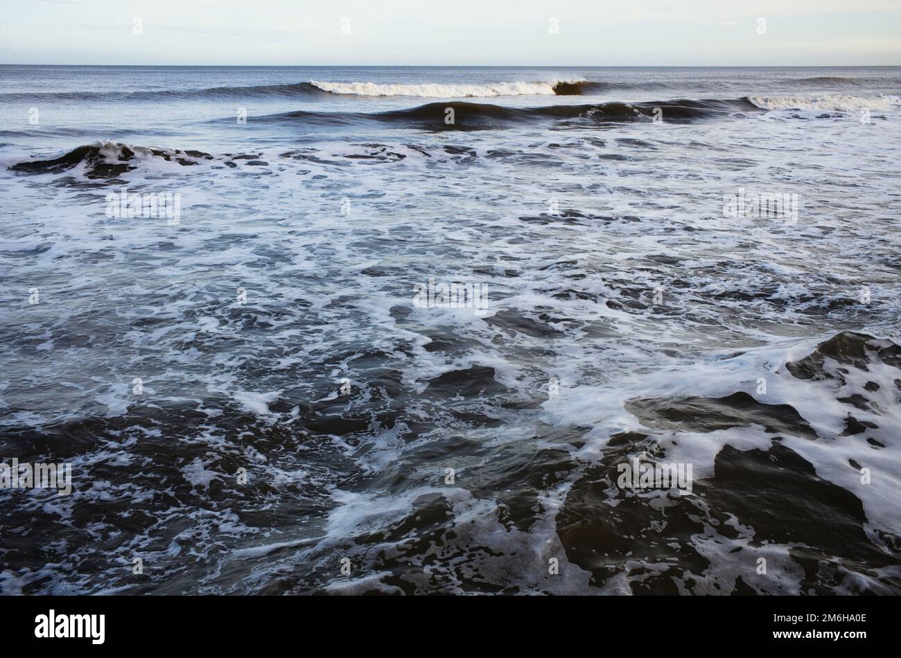 Foamy waves breaking on the shore Stock Photo Alamy