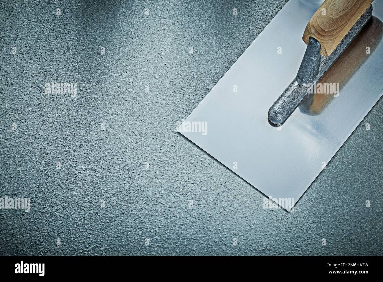 Stainless plastering trowel on concrete background construction concept. Stock Photo