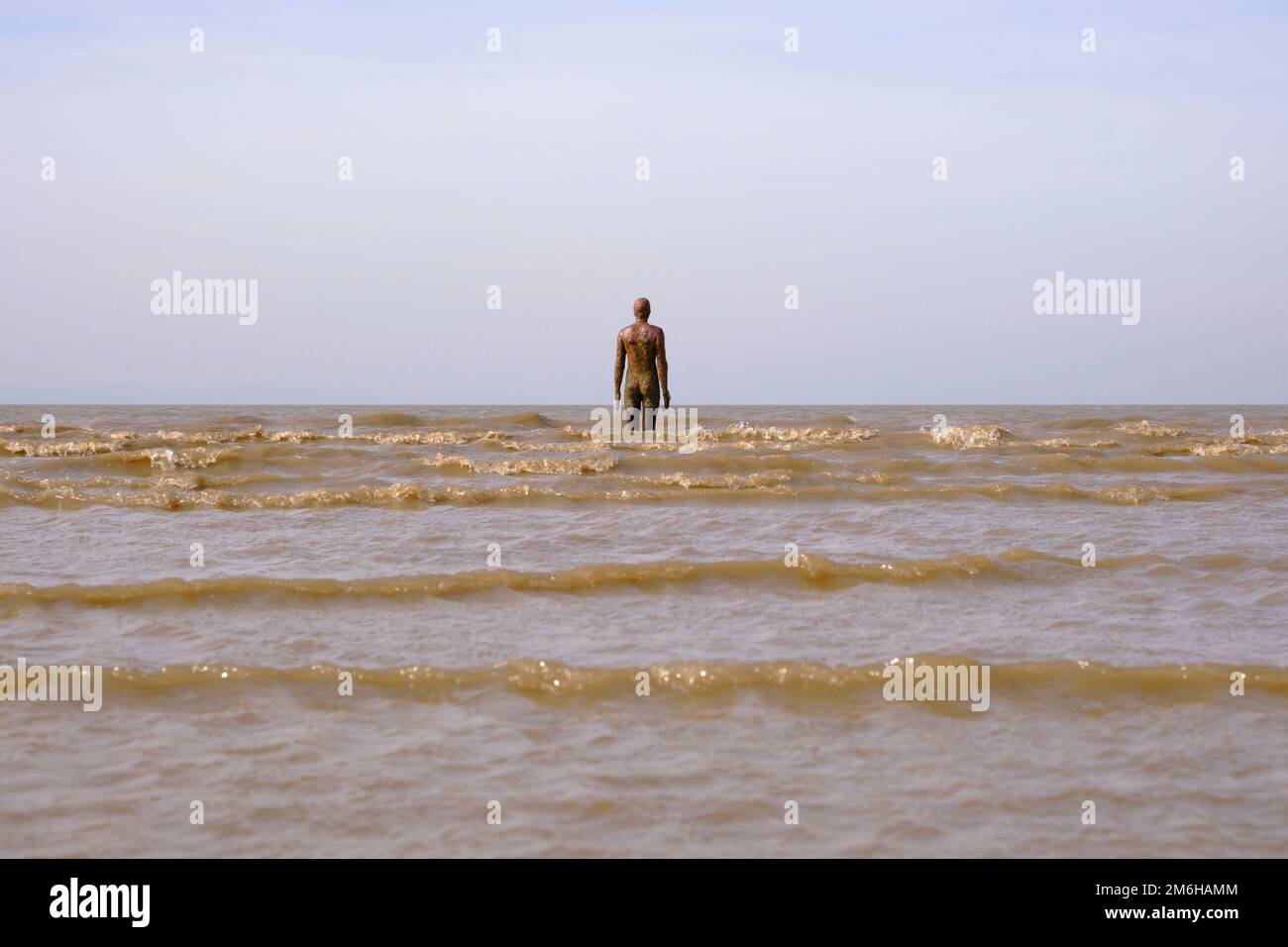 The tide comes in against Anthony Gormley's Sculpture, Another Place on