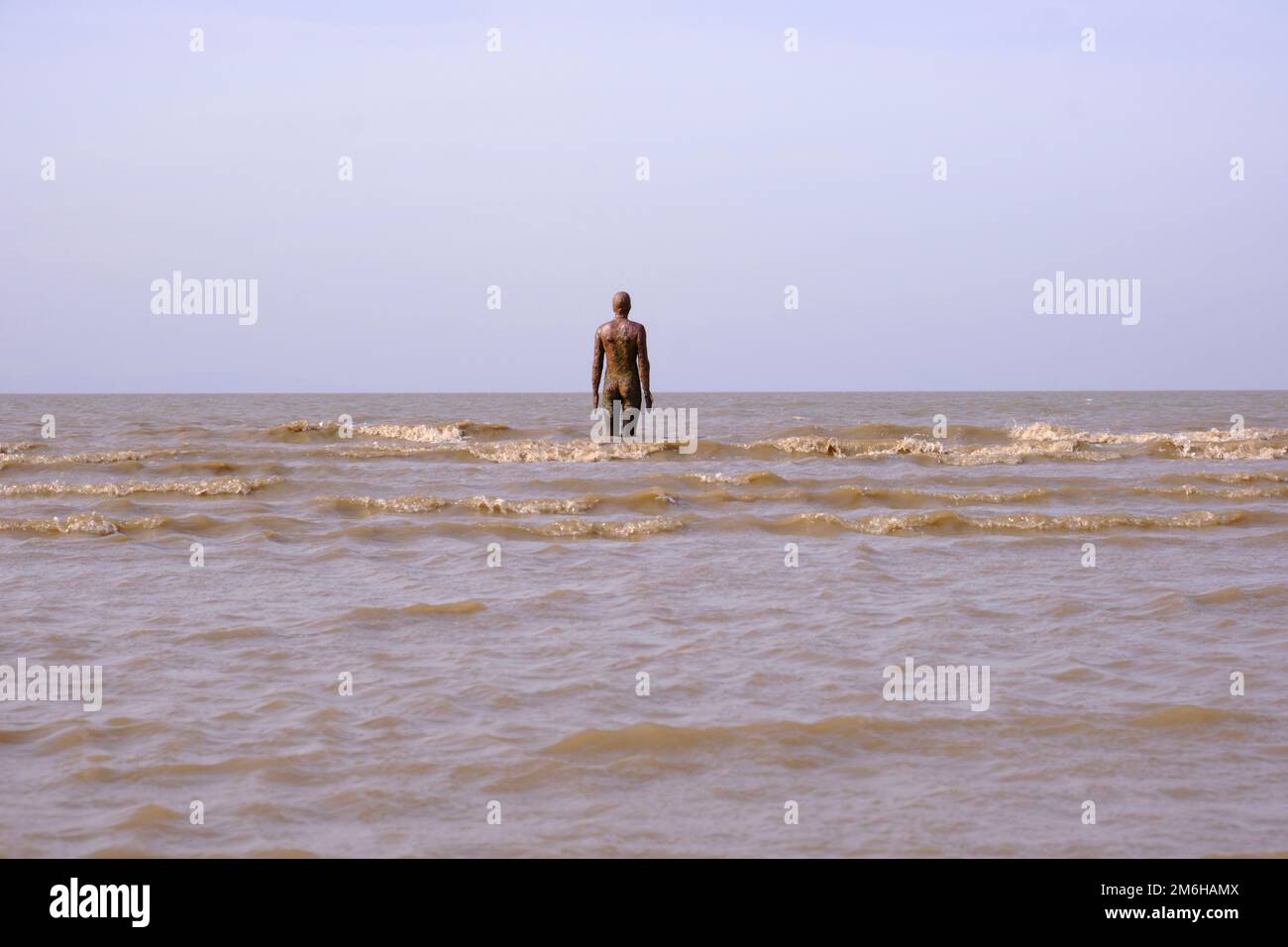 The tide comes in against Anthony Gormley's Sculpture, Another Place on