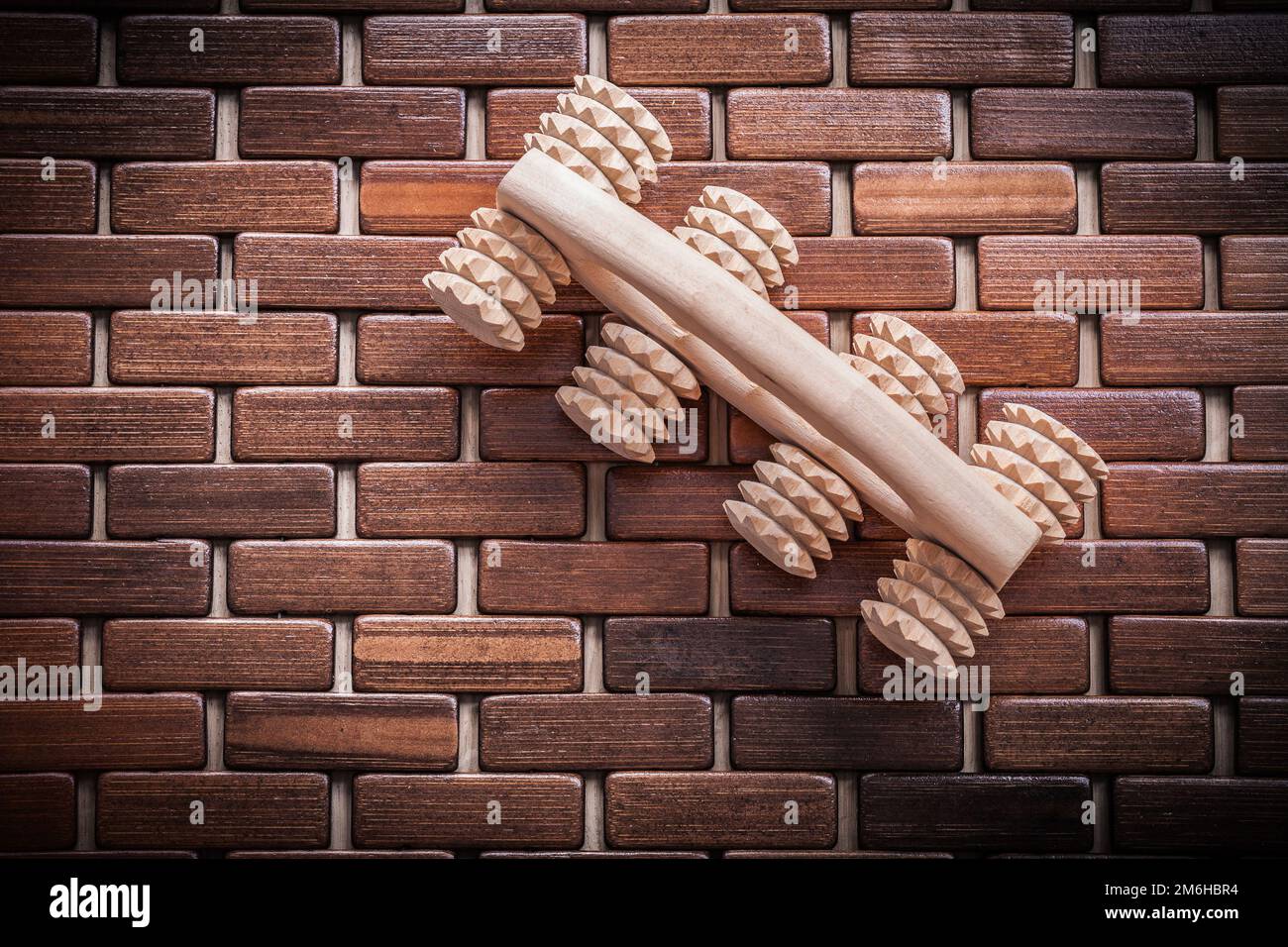 Wood massager with handle on textured wooden mat healthcare concept