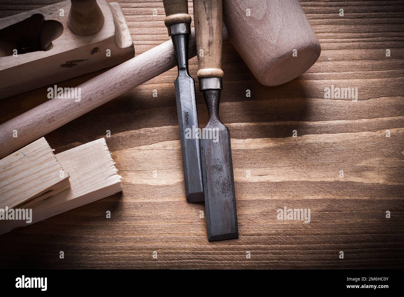 Wooden hammer stud planner flat chisels on wood board construction concept. Stock Photo