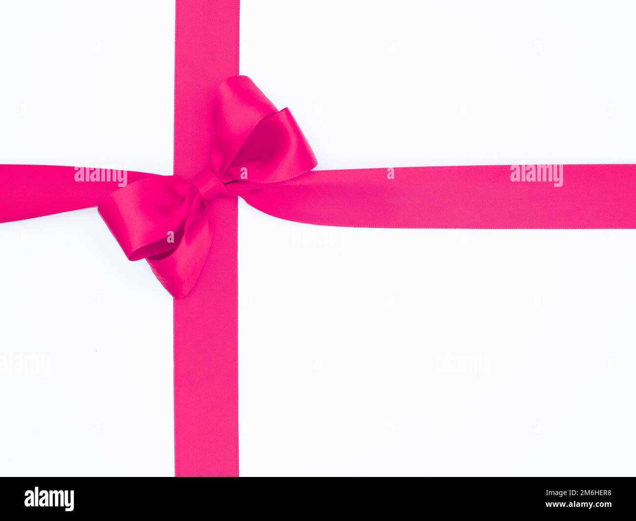 Satin ribbon bow for gift box in pink color, isolated on white