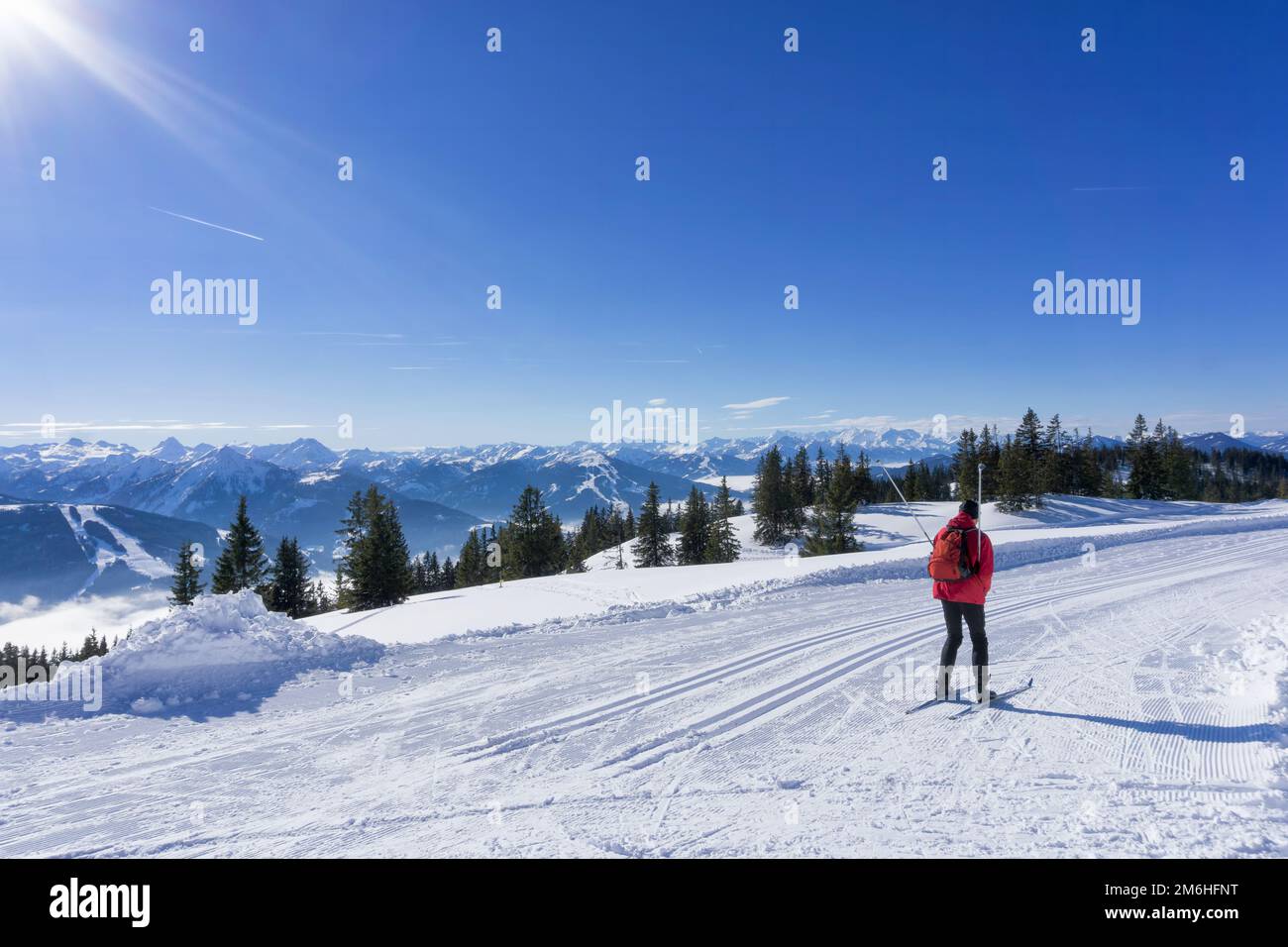 Winter mountain landscape, sunny day in Salzburg Alps. Single cross-country skier on groomed ski trails on top of the Rossbrand Mountain. Stock Photo