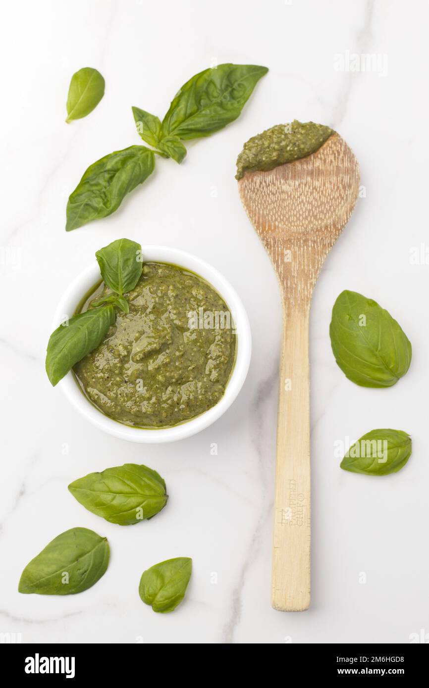 Flatlay of pesto, basil, and a spoon. Stock Photo