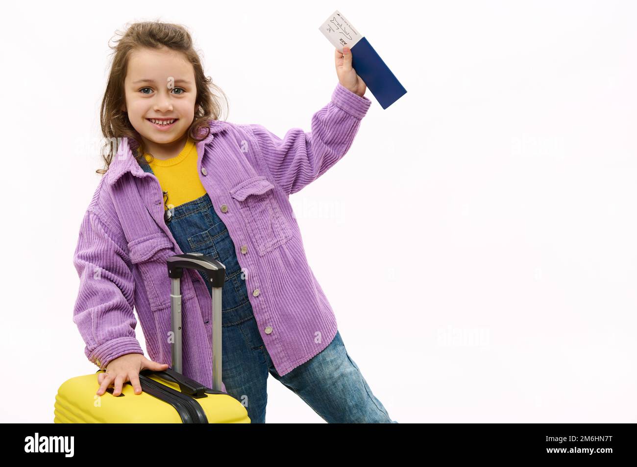 Little girl in purple velvet jacket, smiles at camera, posing with