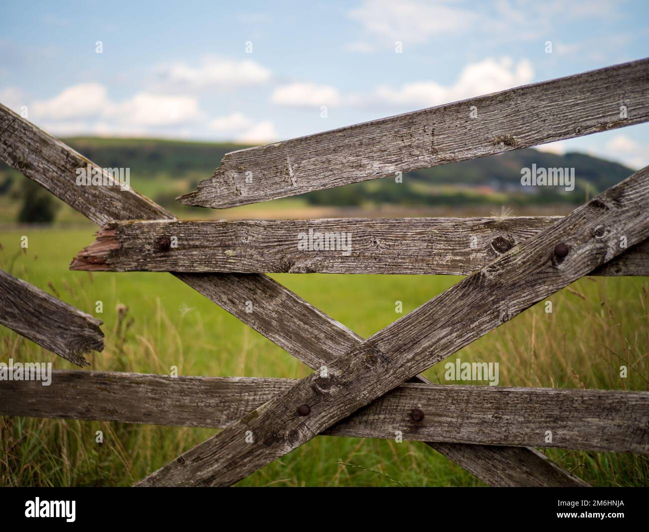 A wooden fence with a background of stone buildings in a countryside ...