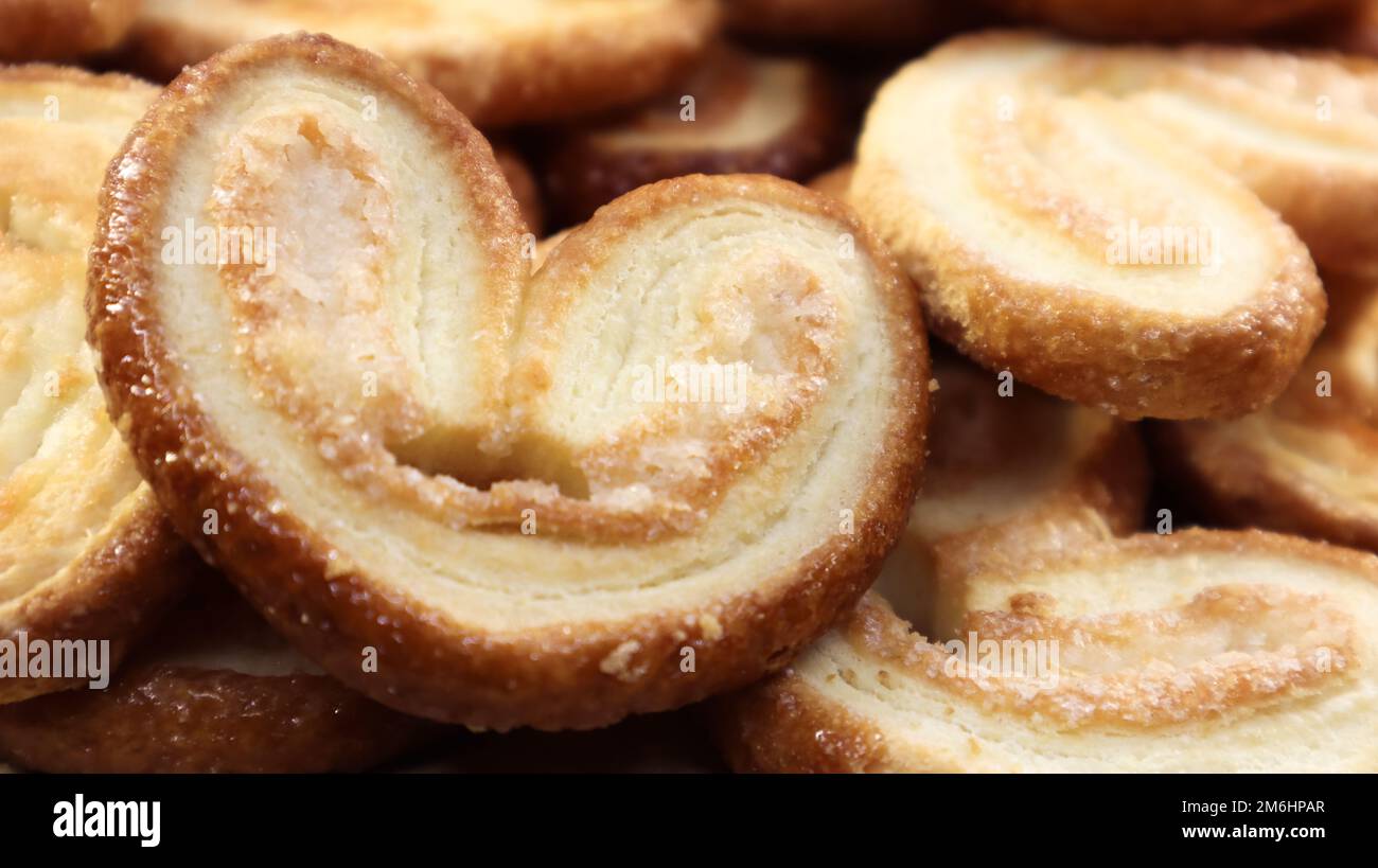 Fresh puff pastry palm cookies in the shape of a heart. Classic French
