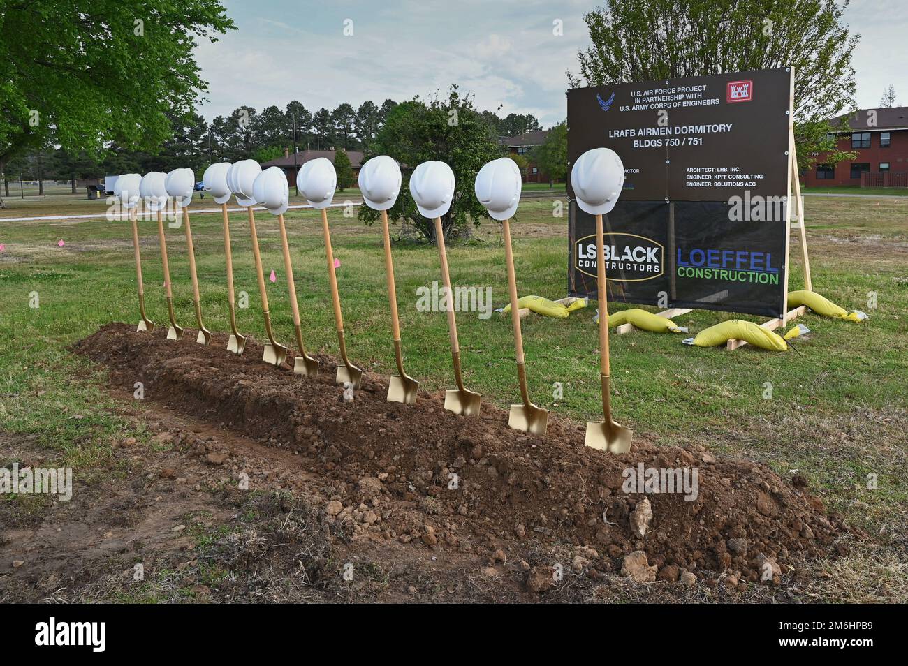 A row of shovels and hardhats is placed at the site of a new dormitory construction project during a groundbreaking ceremony at Little Rock Air Force Base, Arkansas, April 28, 2022. The $32 million project will construct two three-story permanent party enlisted dormitories to house 136 E-1 to E-4 military personnel in single occupancy dorms. Stock Photo