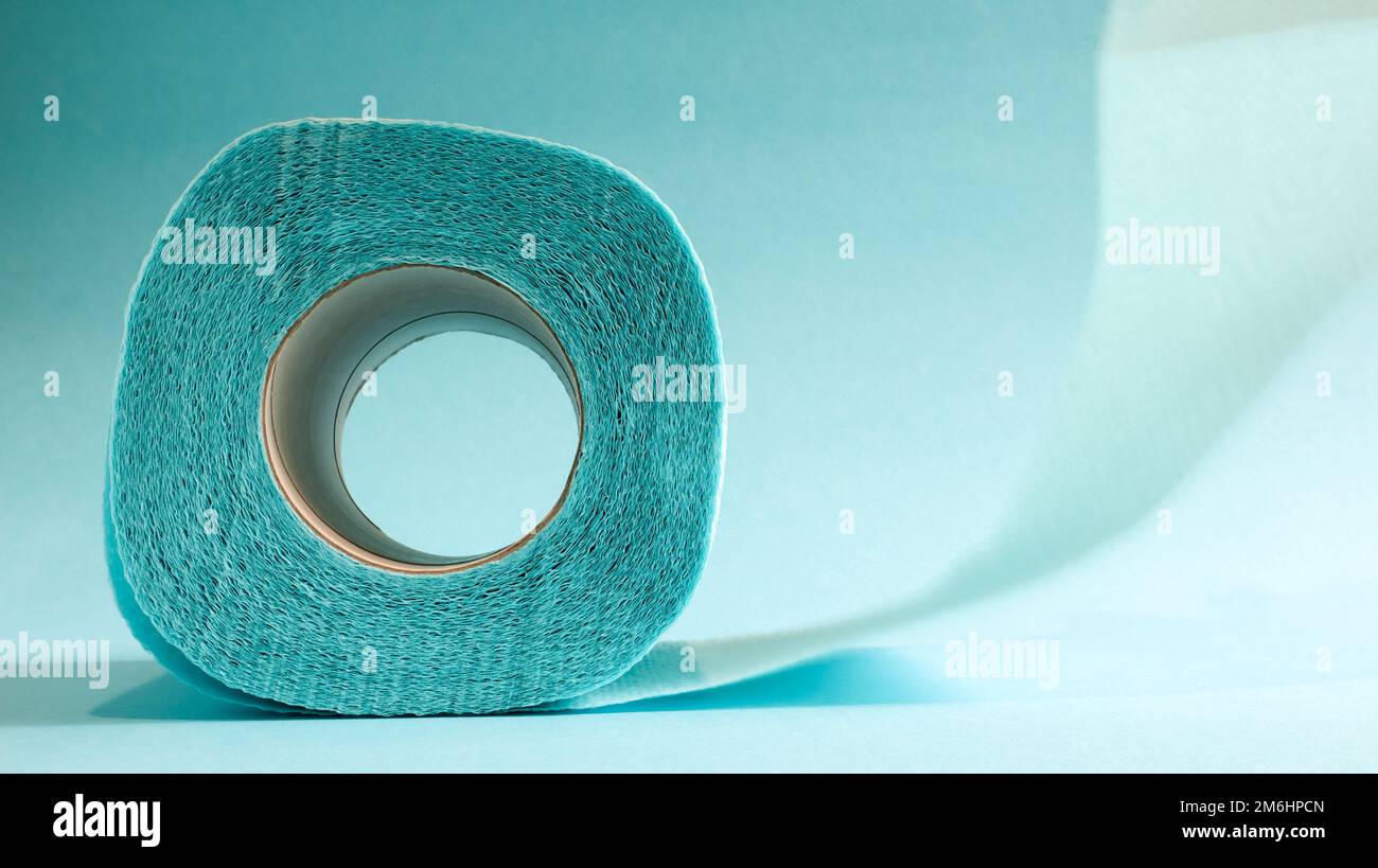 Blue roll of modern toilet paper on a blue background. A paper product on a cardboard sleeve, used for sanitary purposes from ce Stock Photo