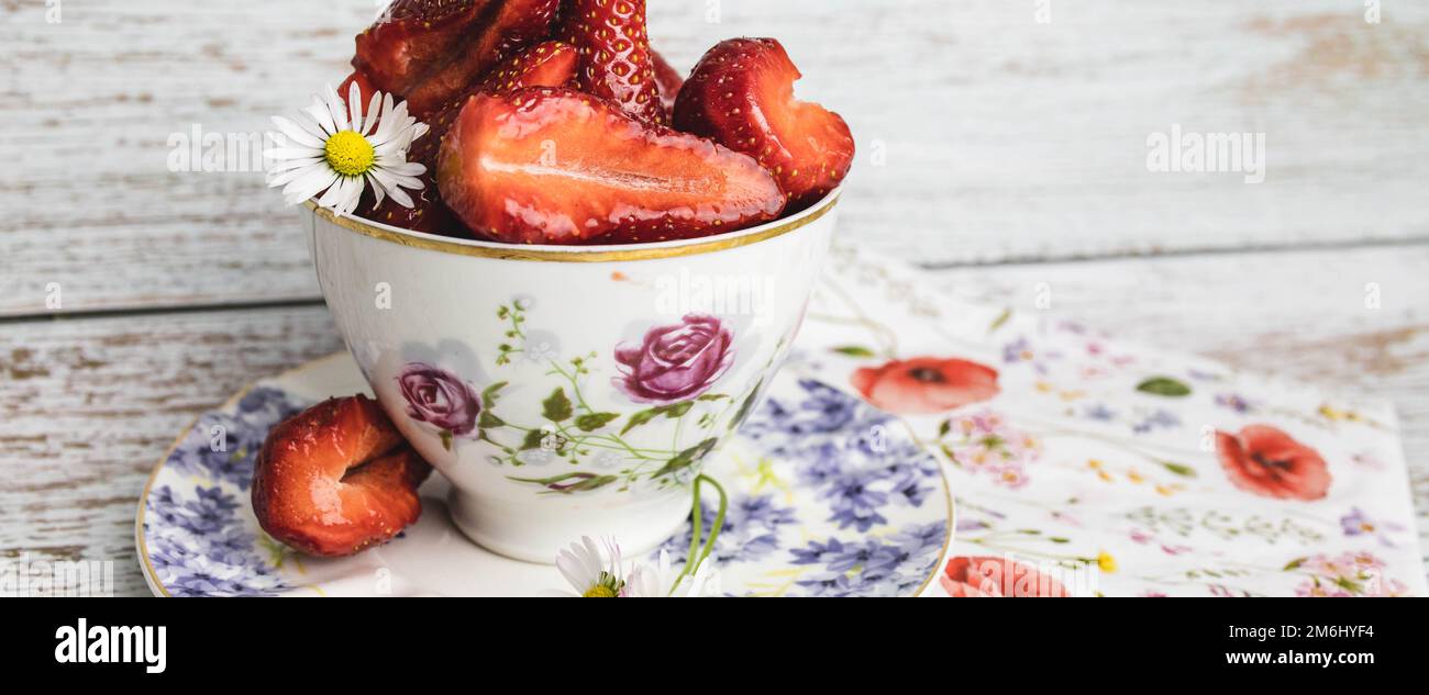 Retro, vintage cup full with strawberries on the table Stock Photo