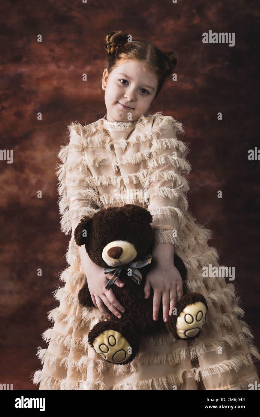 Portrait of a little red hair girl holding teddy bear Stock Photo