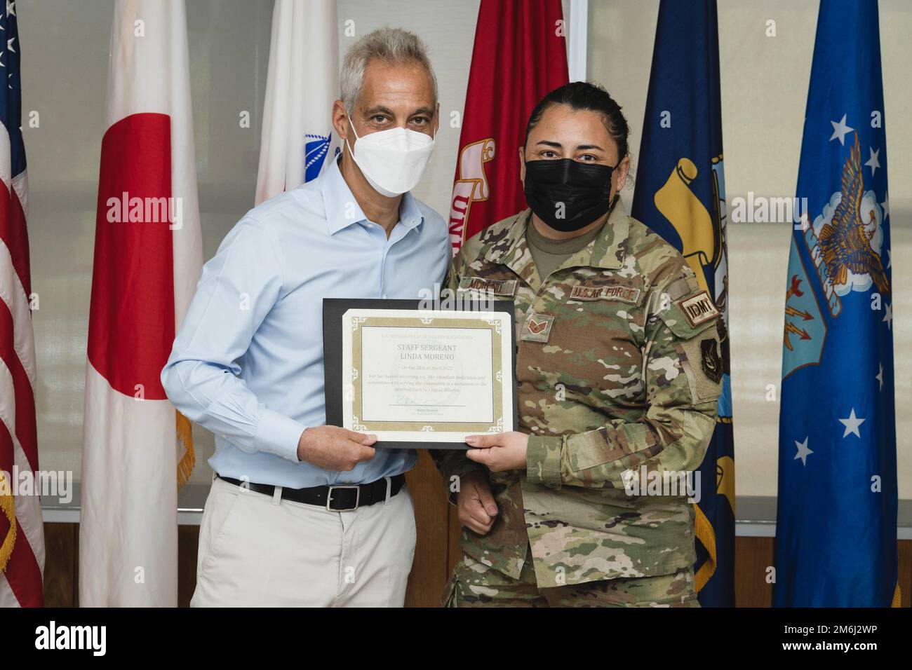 Rahm Emanuel, the U.S. ambassador to Japan, awards U.S. Air Force Staff Sgt. Linda Moreno, a medical technician with 44th Fighter Squadron, 18th Wing, during a recognition luncheon on Camp Foster, Okinawa, Japan, on April 28, 2022. Moreno received a challenge coin for providing life-saving medical care to a Japanese man on a train after he passed out due to possible hypoglycemia at the Yukohashi Train Station, Fukuoka, Japan on March 28, 2022. During Ambassador Emanuel's visit to Okinawa, he took the time to recognize service members and on-base local national employees for their heroic acts a Stock Photo