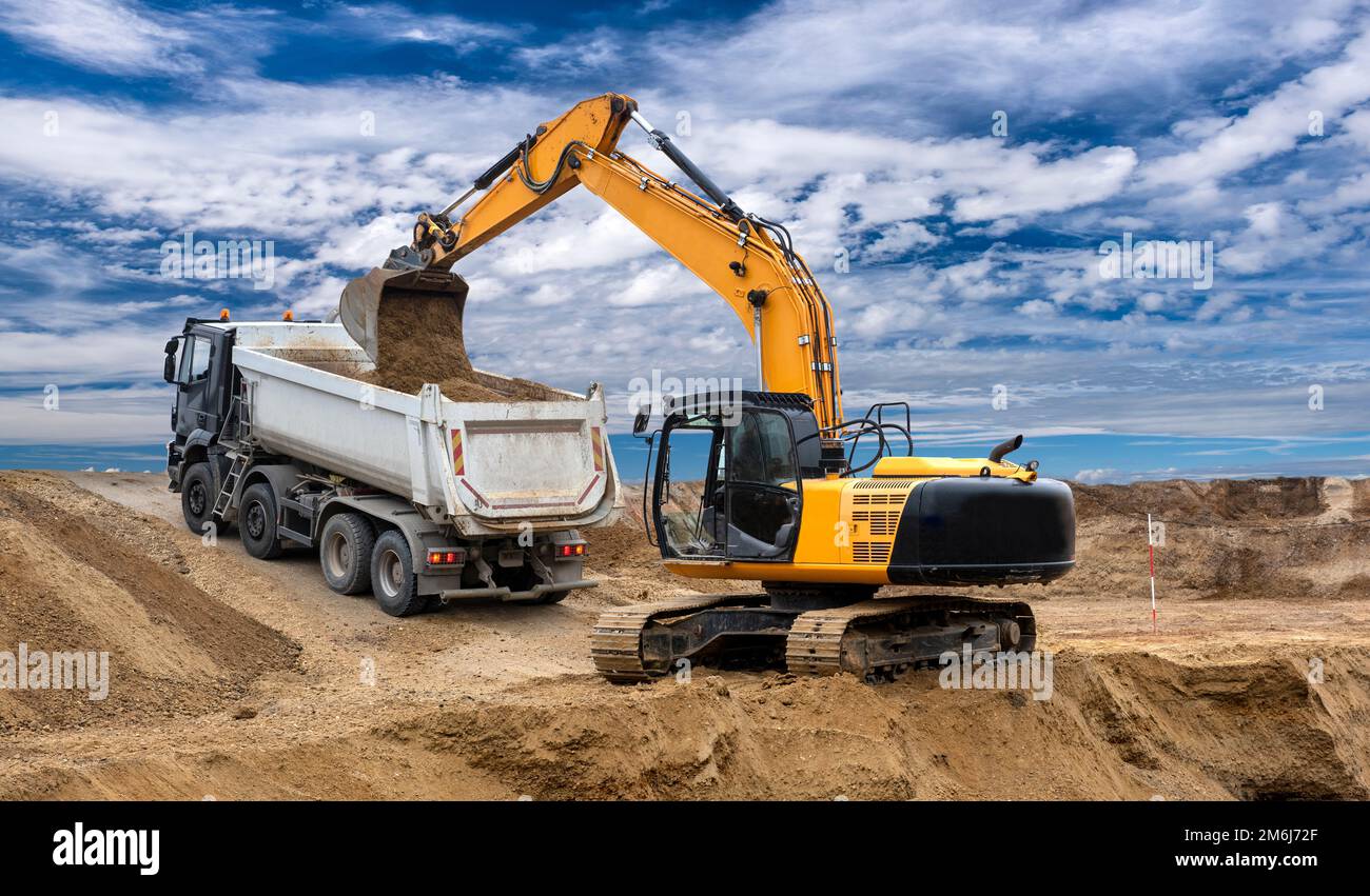 Heavy excavator working on construction site Stock Photo - Alamy