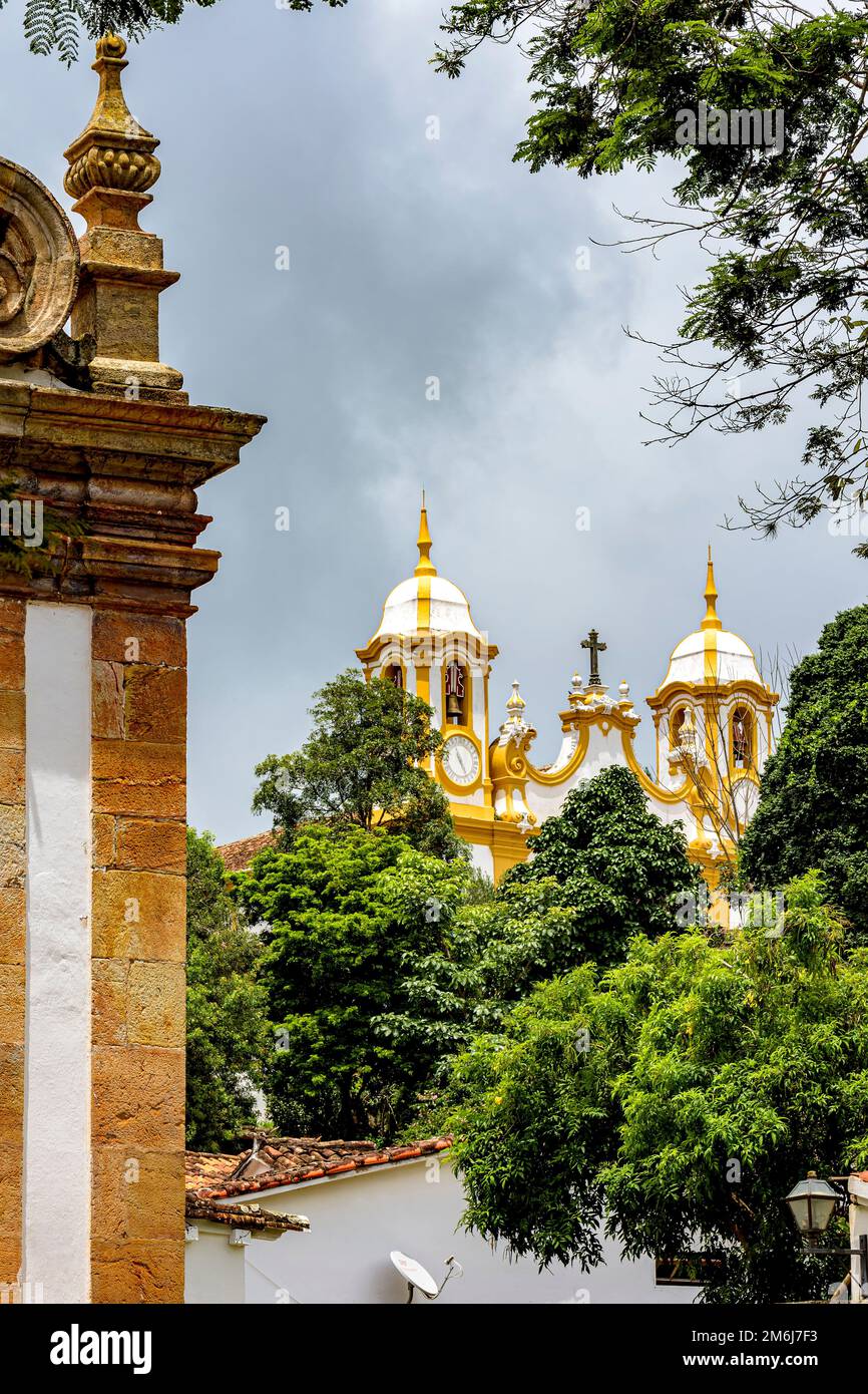 Church tower and old buildings among the vegetation of the historic city of Tiradentes Stock Photo