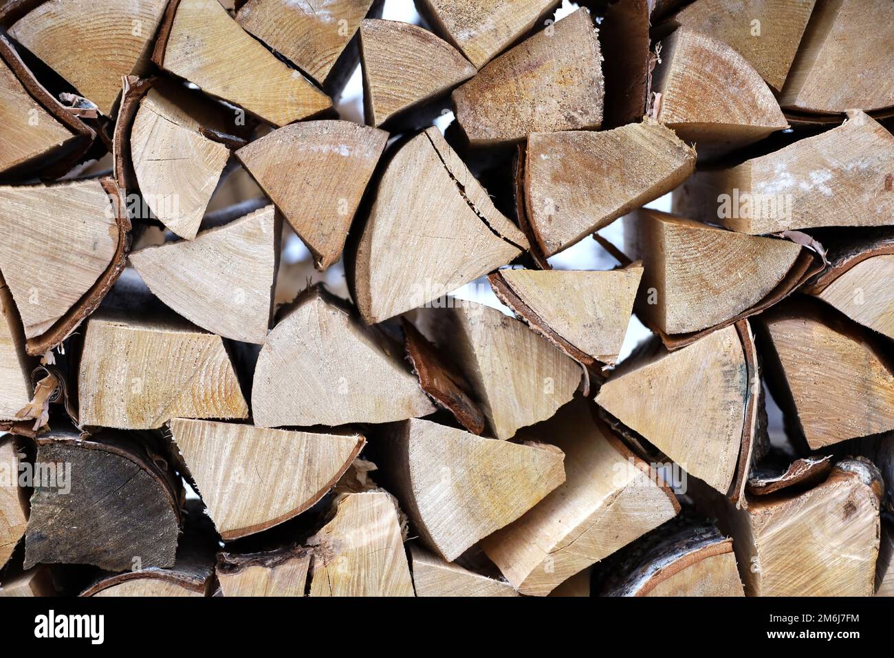 Chopped firewood in the woodpile. Stack of wood on winter street Stock Photo