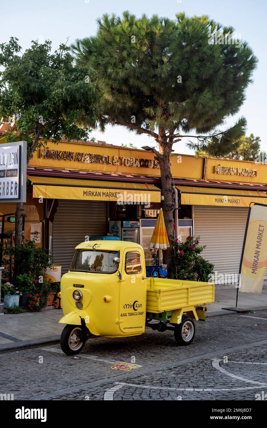 Akyaka, Mugla, Turkey. September 8th 2022 A bright yellow delivery van parked outside a market shop in the Cittaslow Turkish Riviera town of Akyaka in Stock Photo