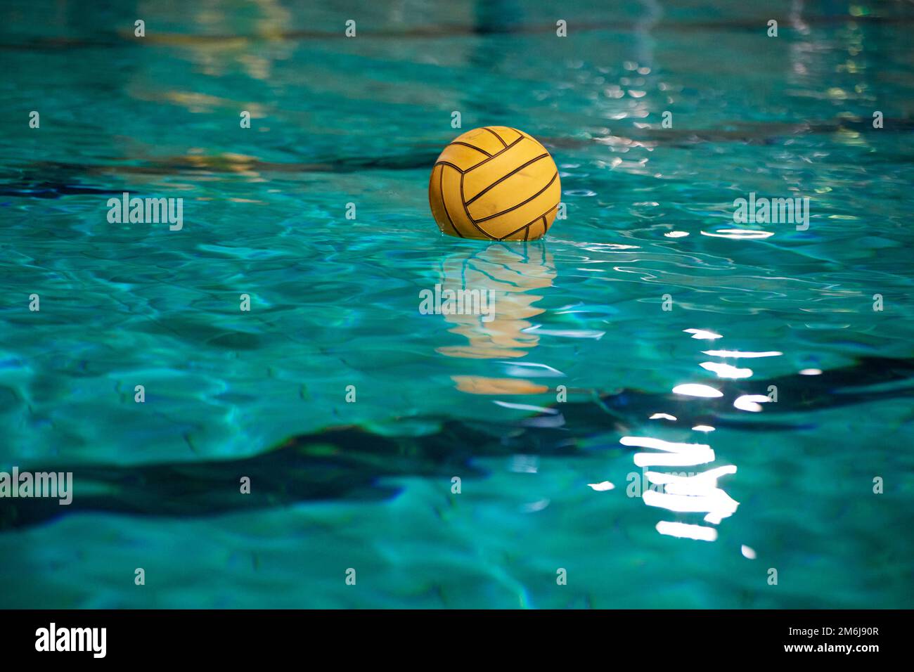 Water polo. Yellow water polo ball in a swimming pool on blue water