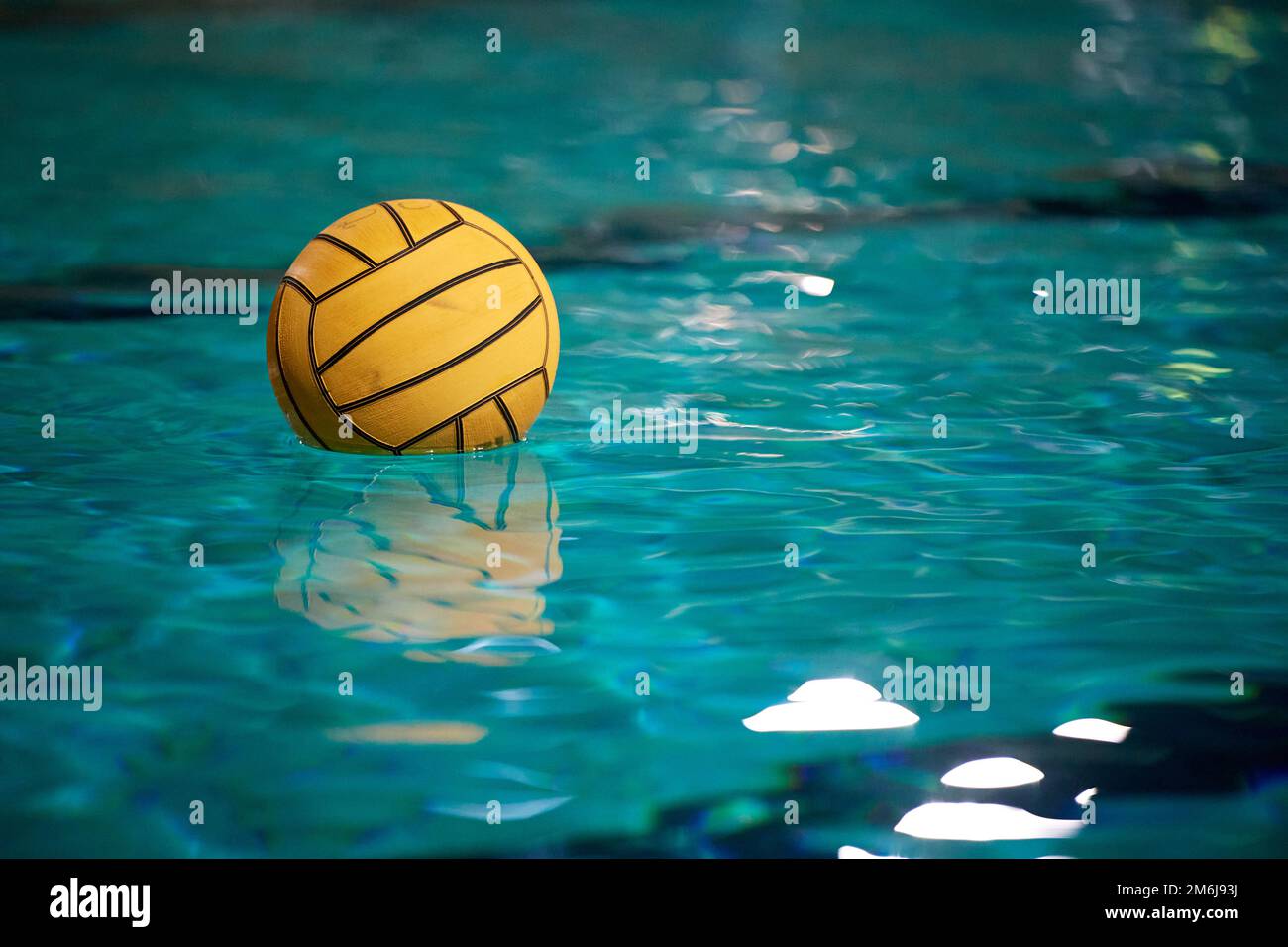 Water polo. Yellow water polo ball in a swimming pool on blue water