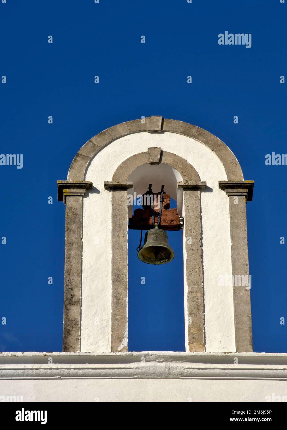 Small bell tower against a blue sky in the Algarve - Portugal Stock Photo