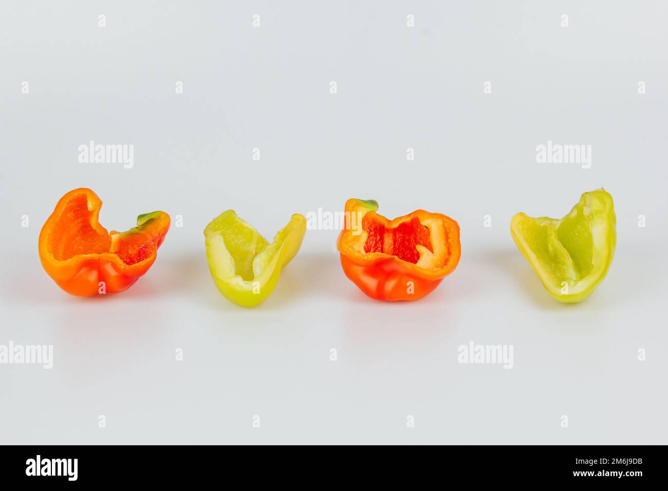 Halved green and red bell peppers isolated on white background. Cutting ...