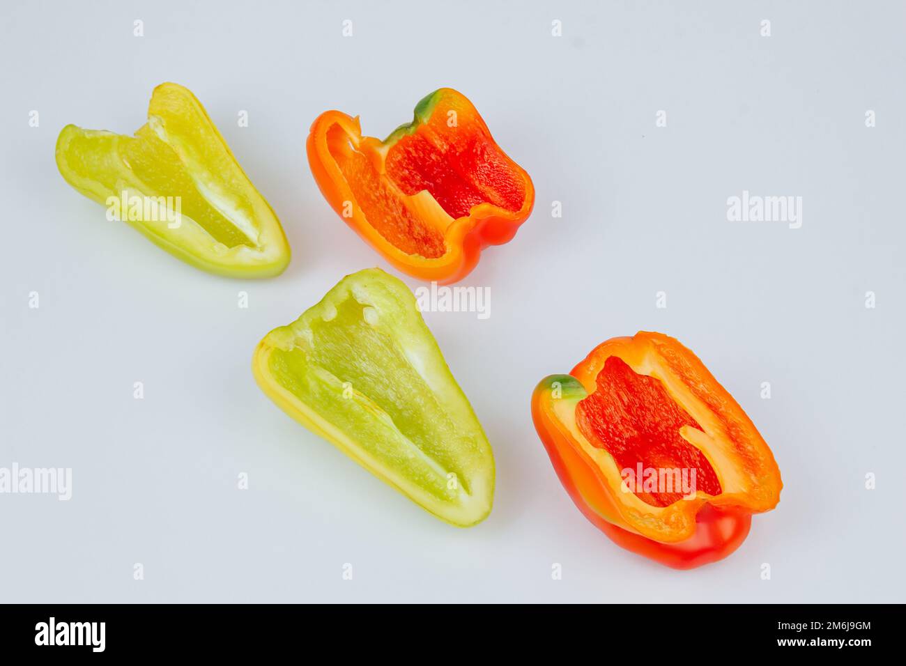 Halved green and red bell peppers isolated on white background. Cutting ...