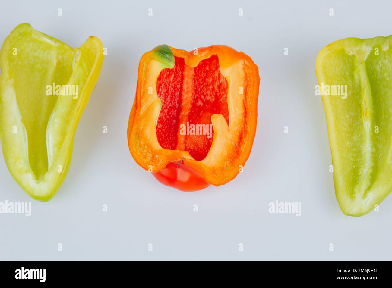 Halved green and red bell peppers isolated on white background. Cutting ...