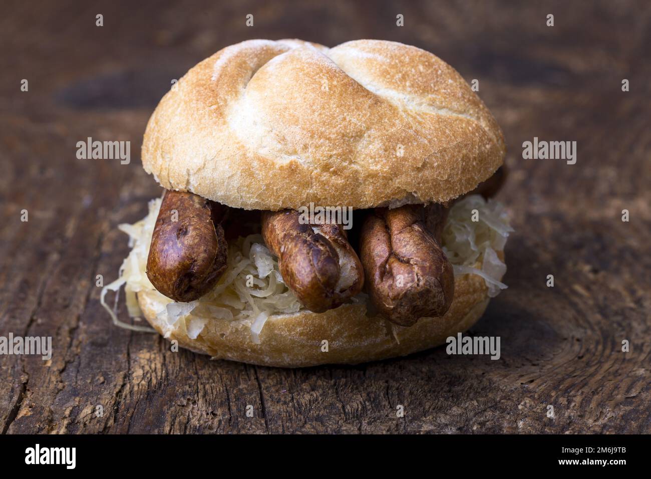 Nuremberg sausages with sauerkraut in a roll Stock Photo