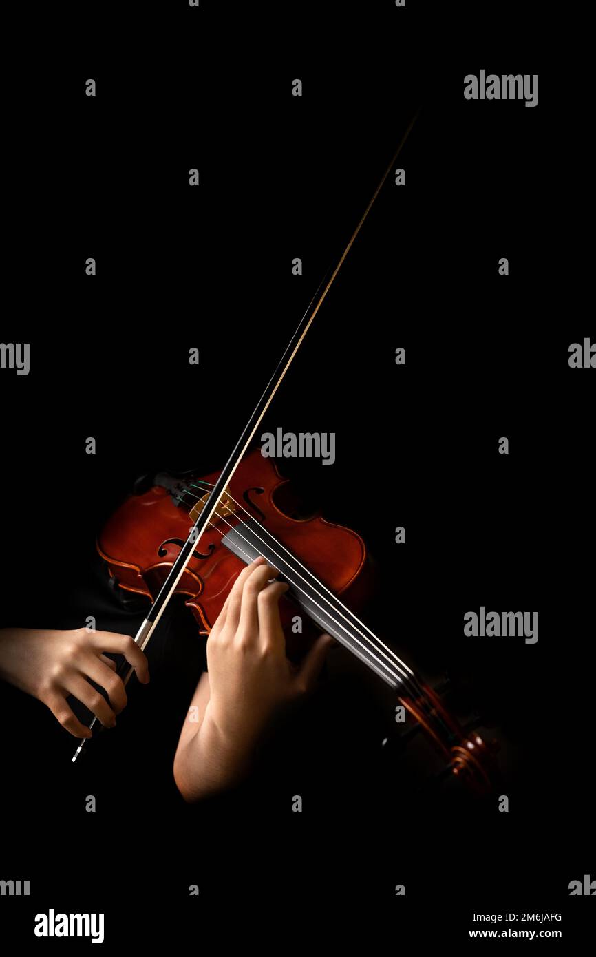 Teen playing violin in black background Stock Photo - Alamy