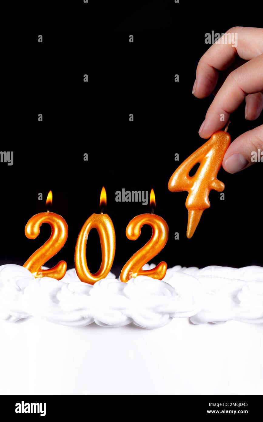 Golden candles write numbers flame Happy new year 2024 hand Stock Photo