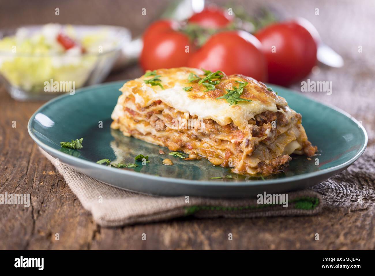 Portion of lasagna on a green plate Stock Photo