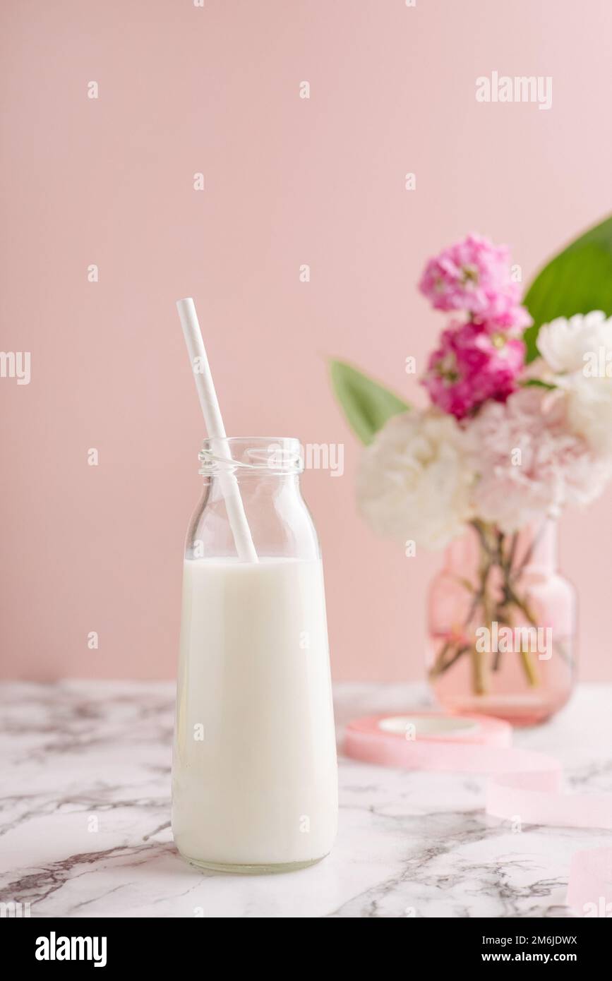 Small glass milk bottle with pink candy stripe paper straws and pink  macarons Stock Photo - Alamy