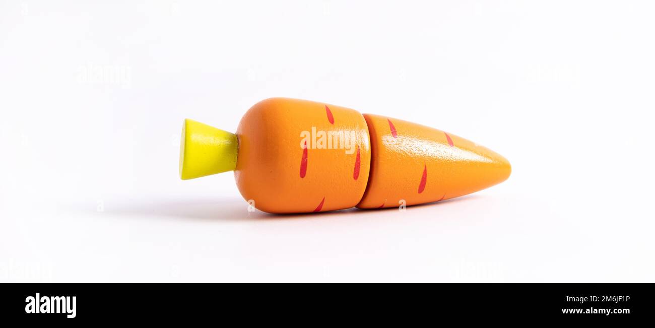 Food toy carrot on white background. Creative wooden design, vegetarian vegetable . Child development. Kids play. Stock Photo