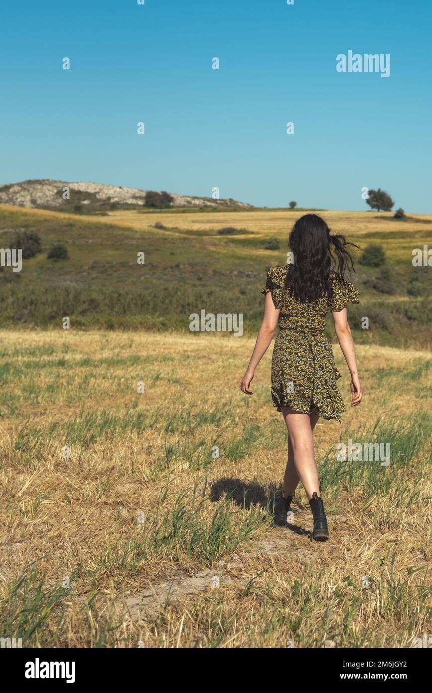 Young attractive woman walking in the field in spring. Fashion lifestyle outdoor Stock Photo