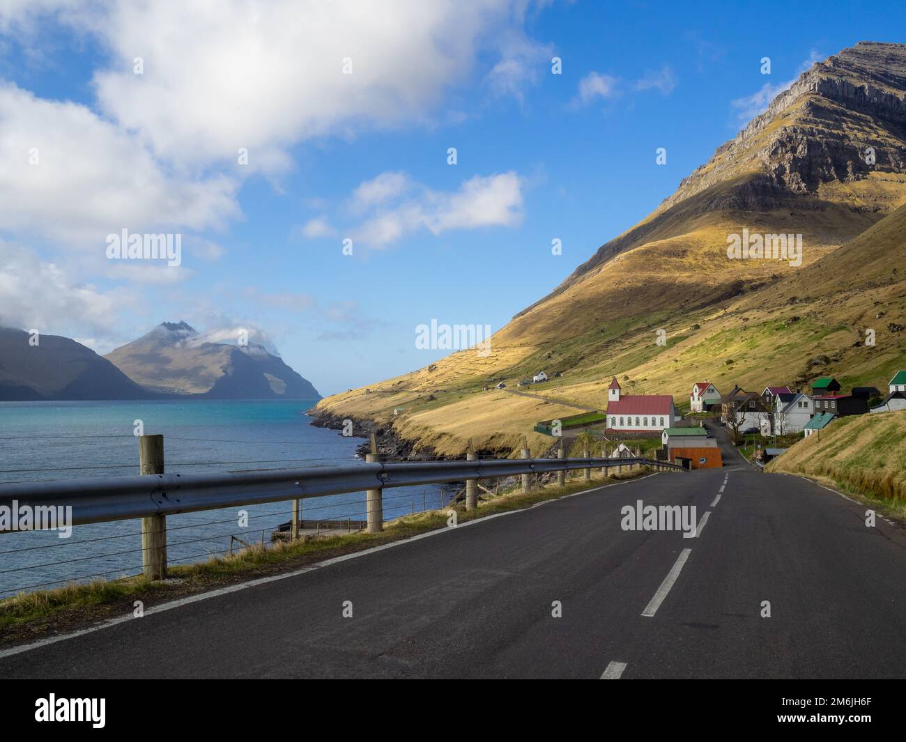 Road to Kunoyar hamlet, below Kúvingafjall mountain, with Kalsoyarfjørður and Kalsoy island on the left Stock Photo