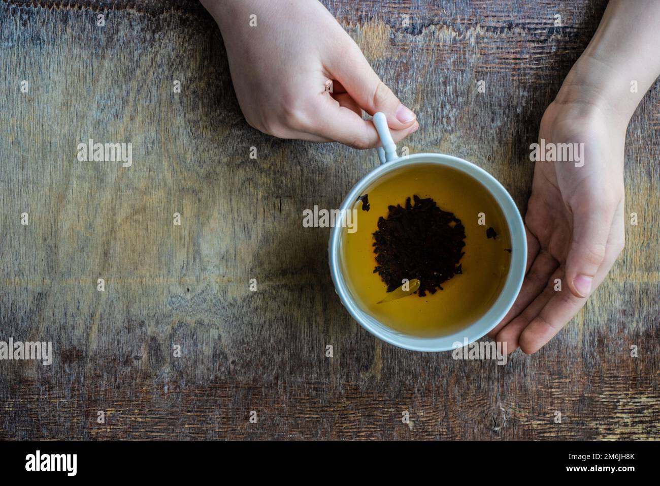 Baby boy holds cup of tea Stock Photo