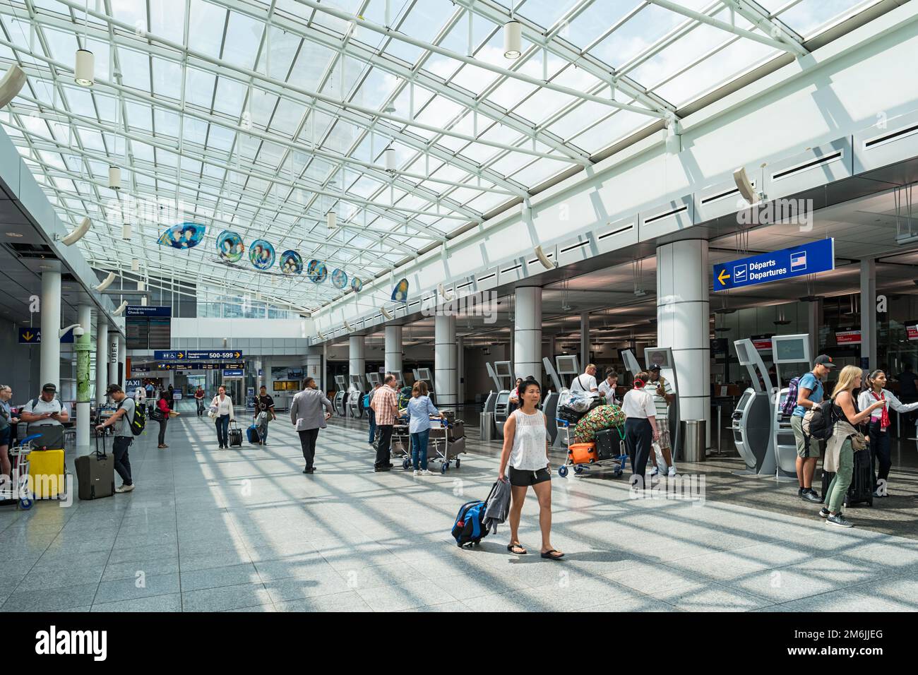 Travelers at Montreal-Pierre Elliott Trudeau International Airport. Stock Photo