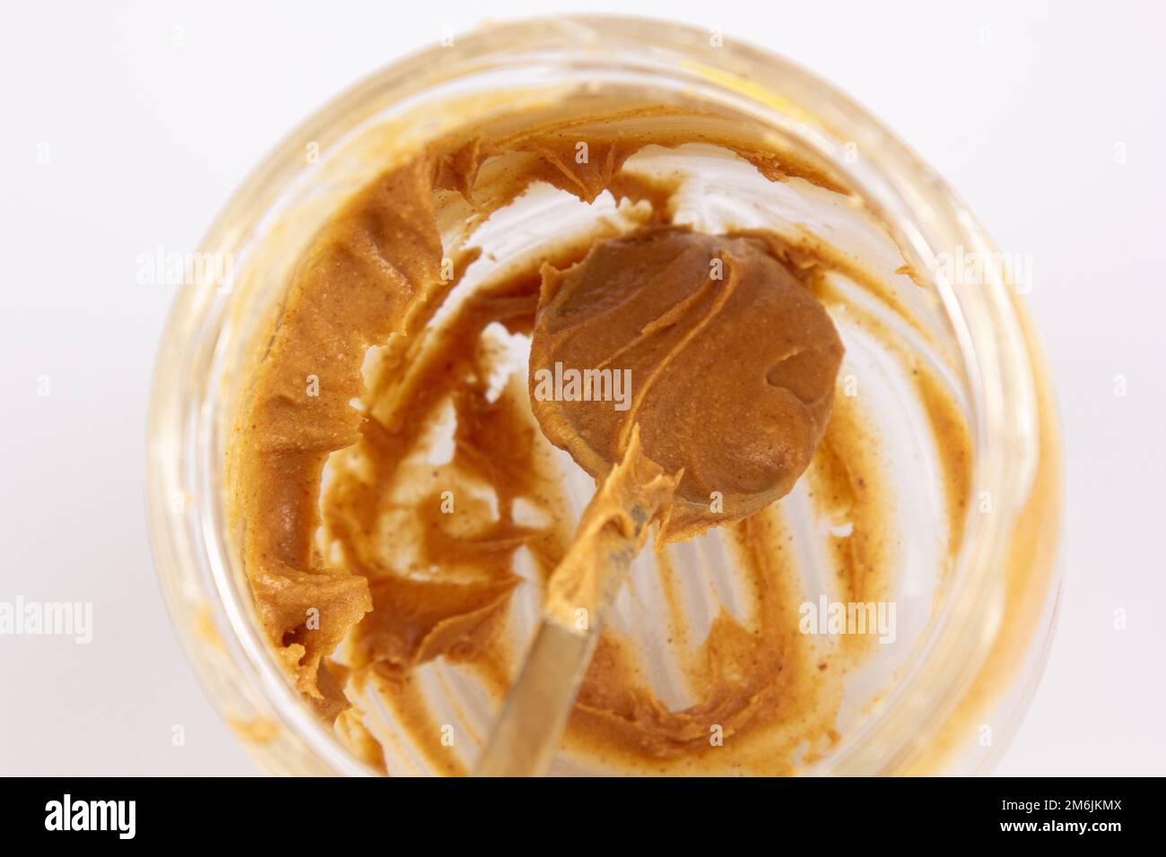 Peanut butter in an open jar. Empty peanut butter container. The last